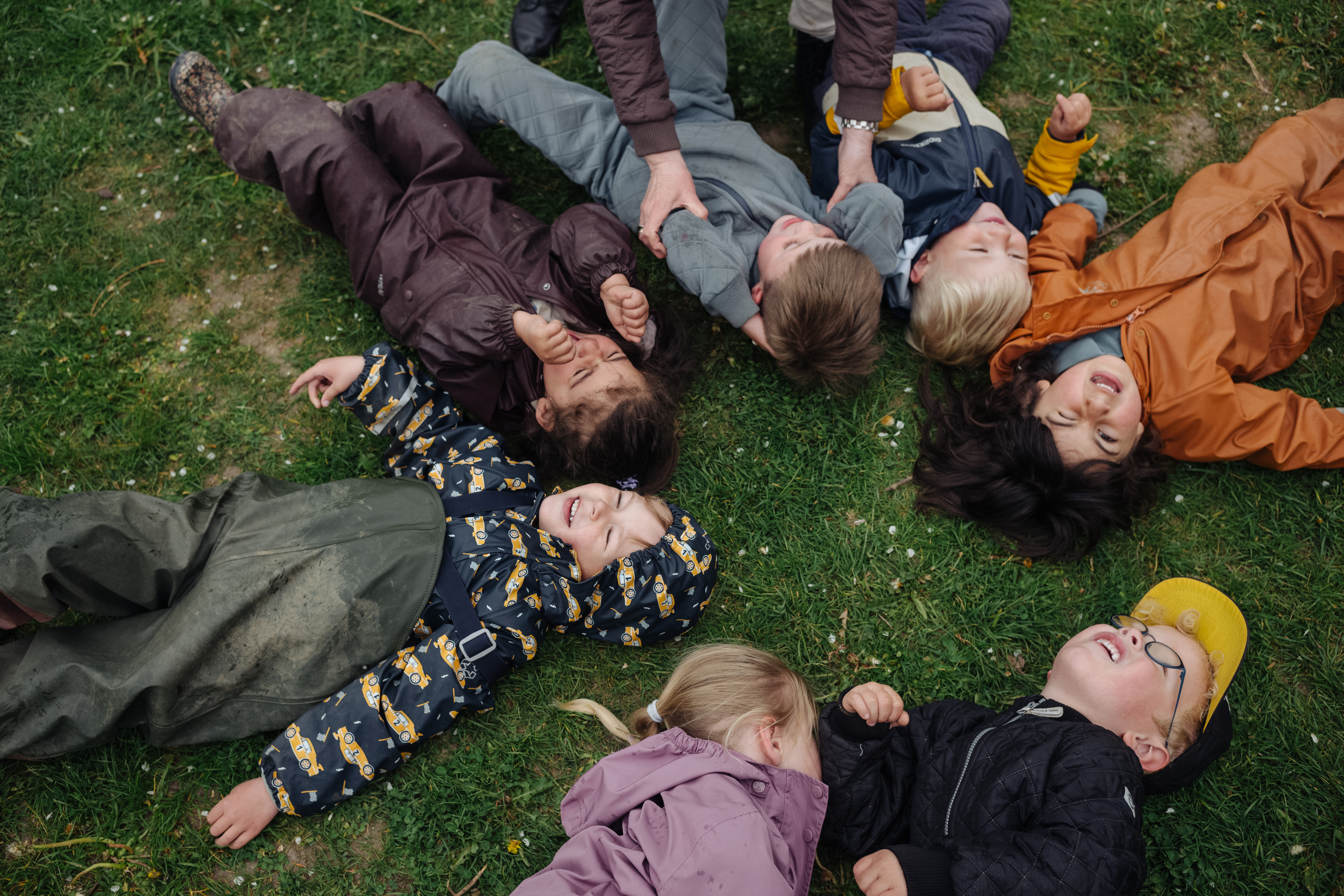 børn ligger på ryggen på græsset